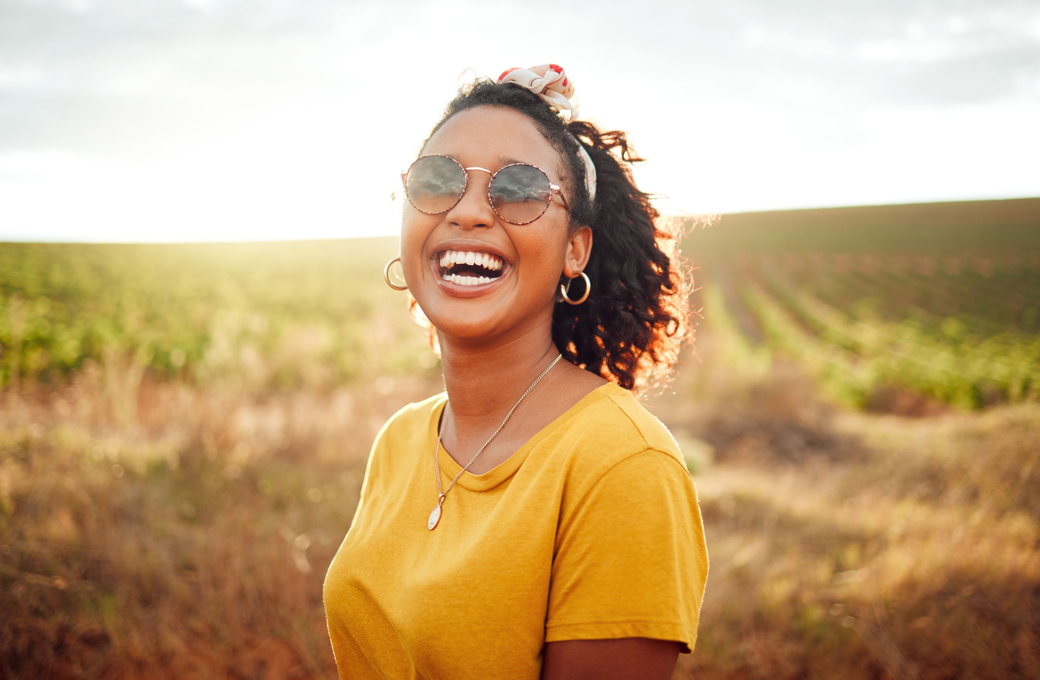 Happy, farm and black woman on holiday in the countryside of Colombia for adventure, peace and calm in summer. Face portrait of African girl with smile for travel vacation in agriculture and nature.
