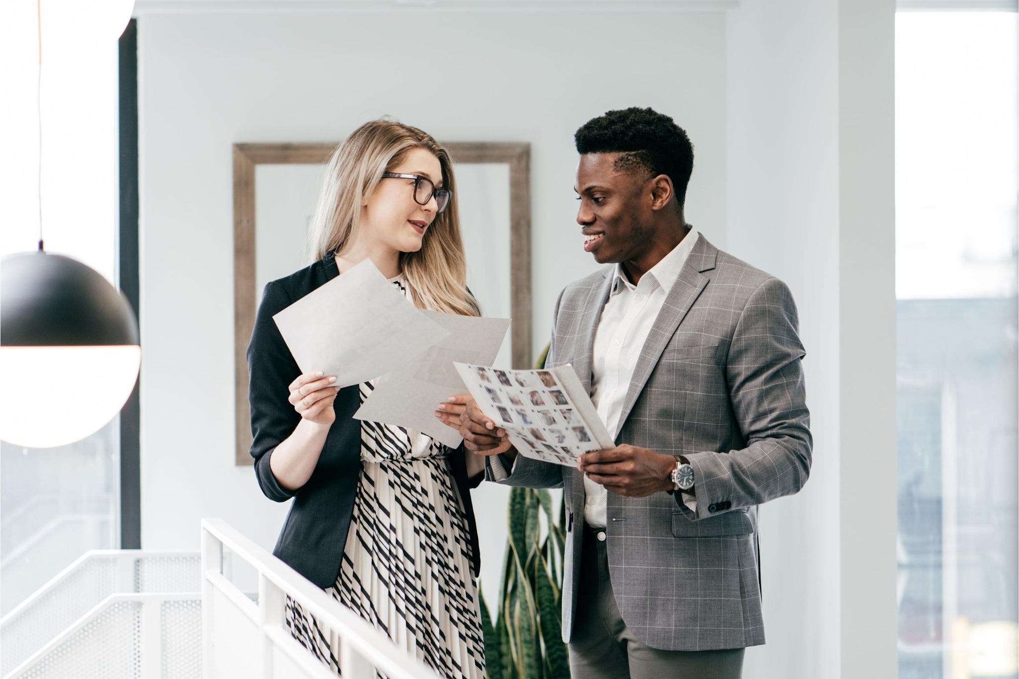 Co-workers standing in office discussing work