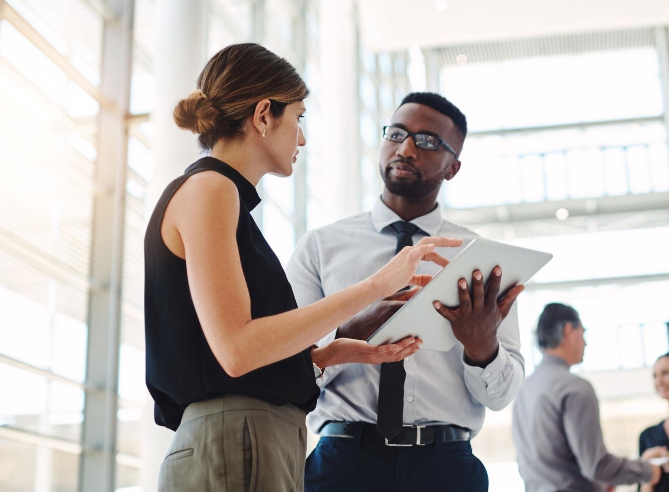 canva-diverse-male-female-colleagues-office-standing-discussing