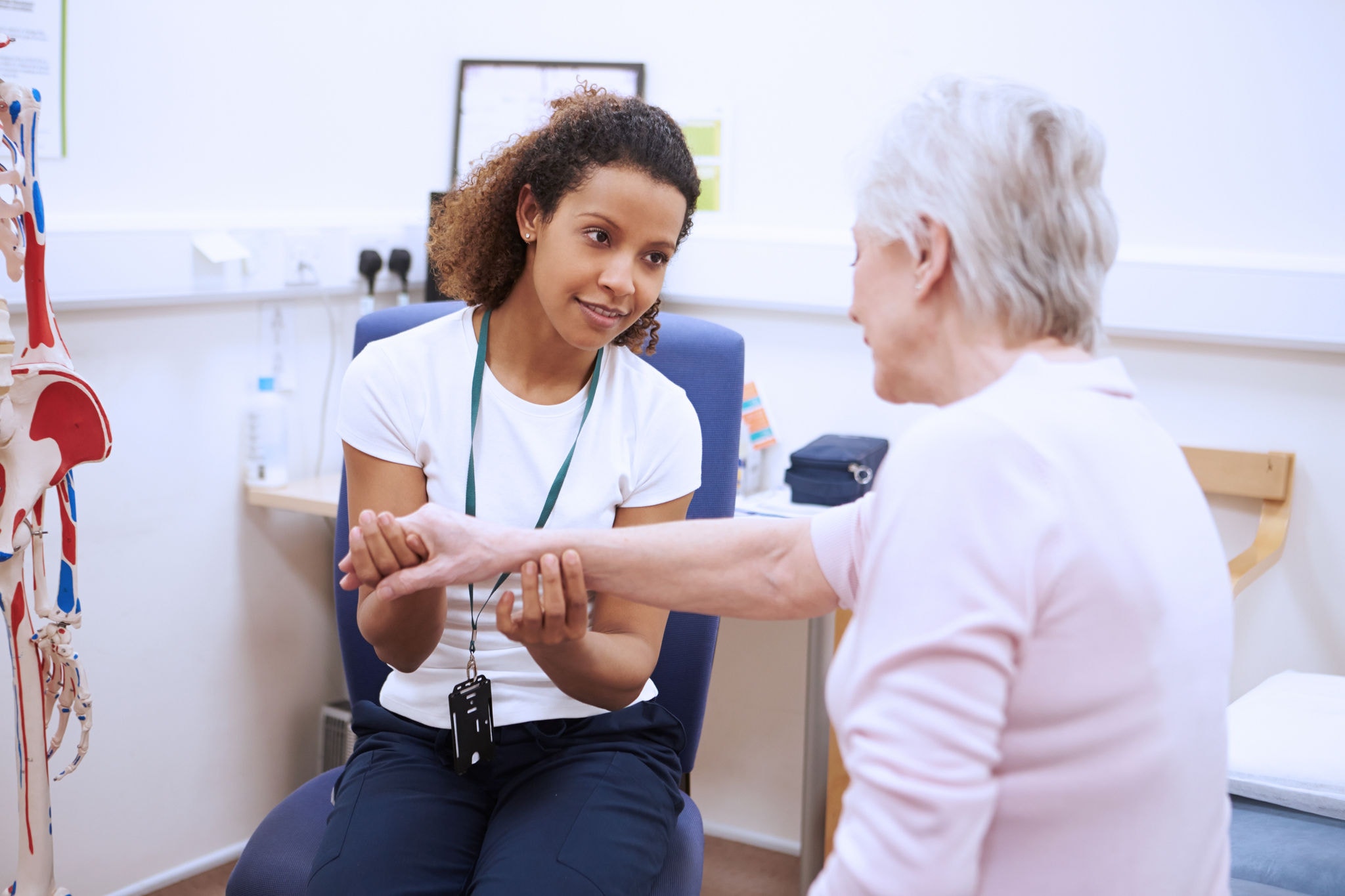 Doctor examining an elderly woman's wrist