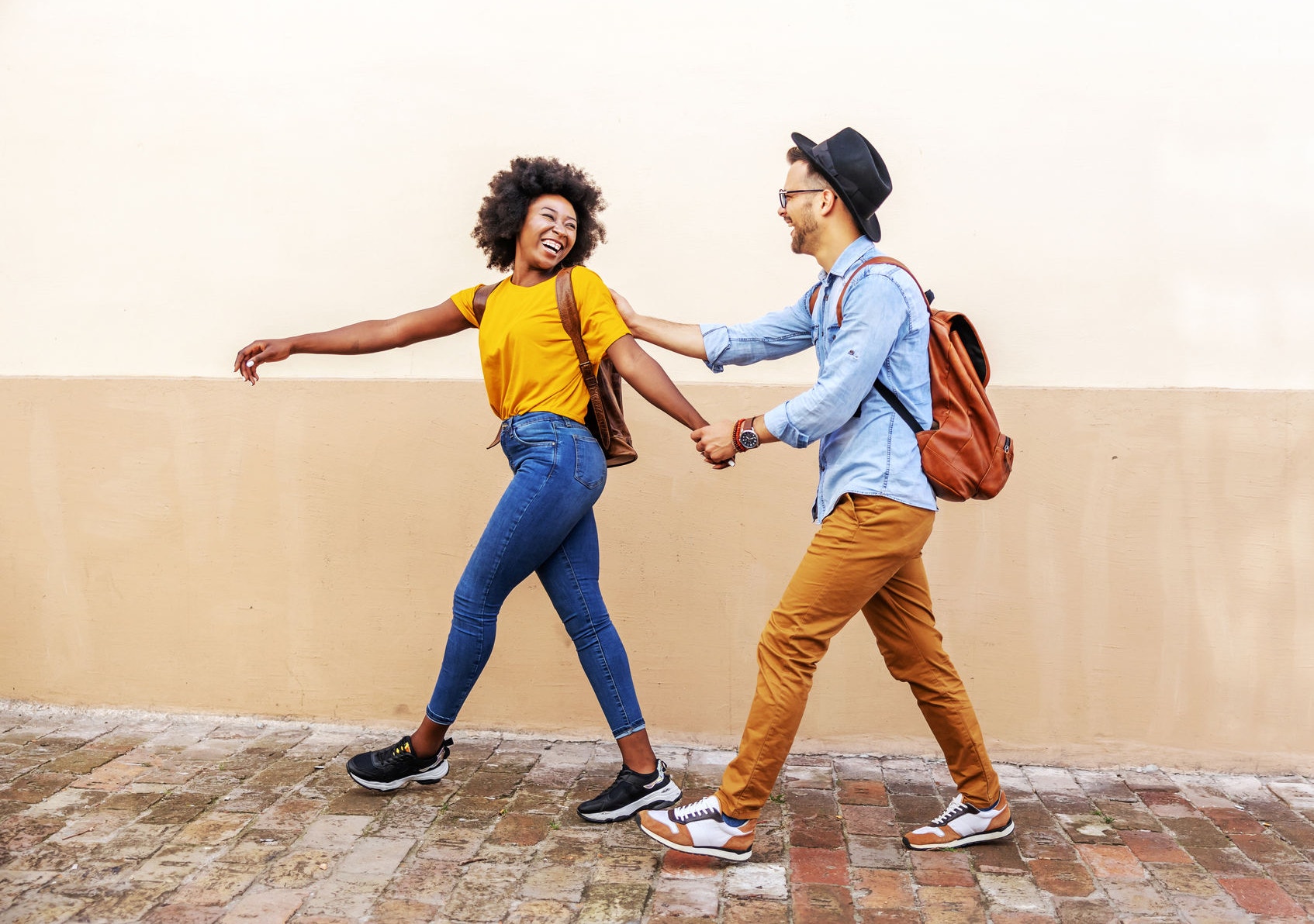 Young happy couple walking outdoors holding hands