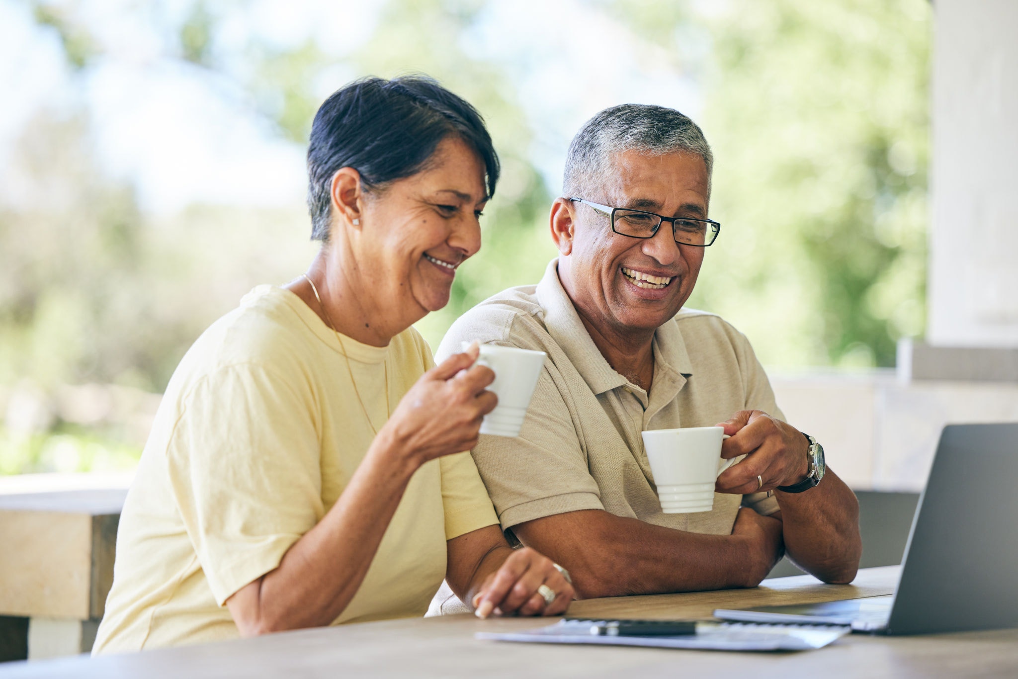 Couple using their laptop whilst enjoying a coffee