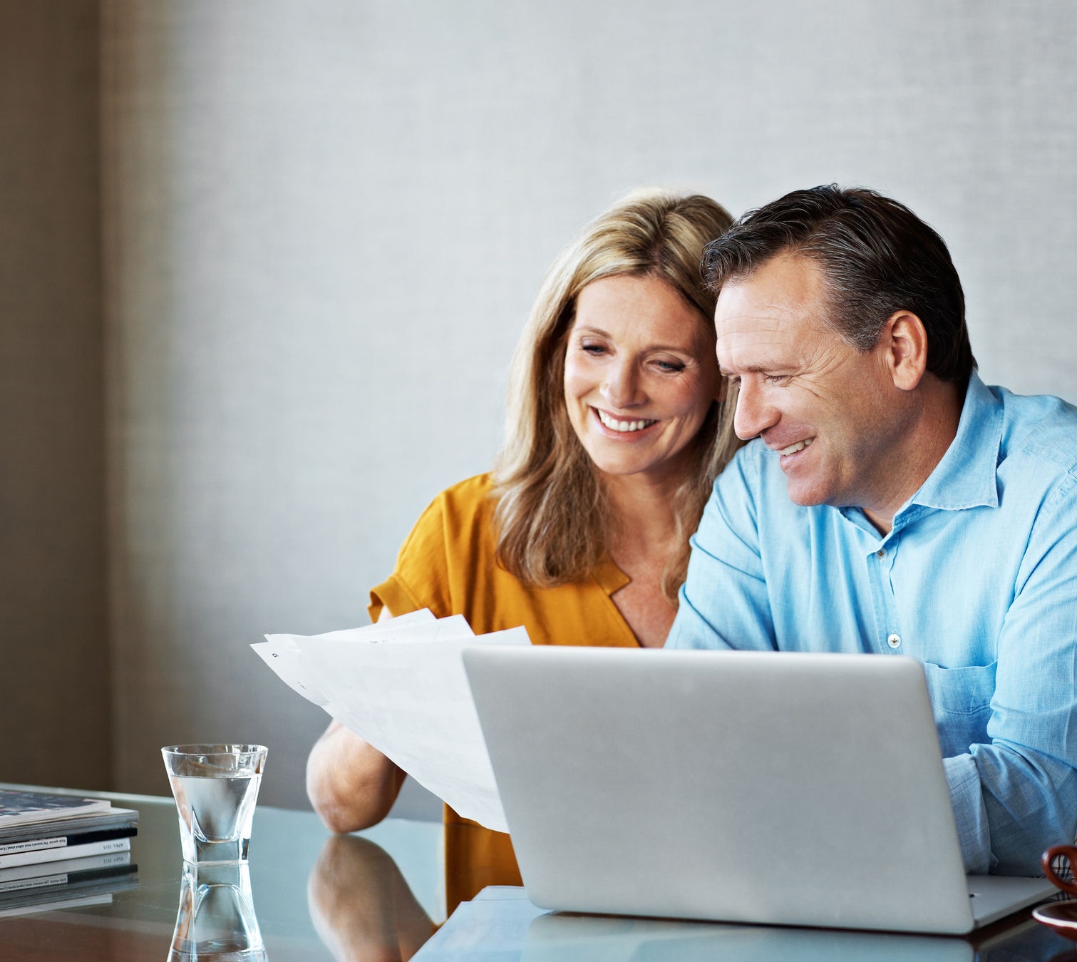 Shot of a mature couple paying their bills online from home