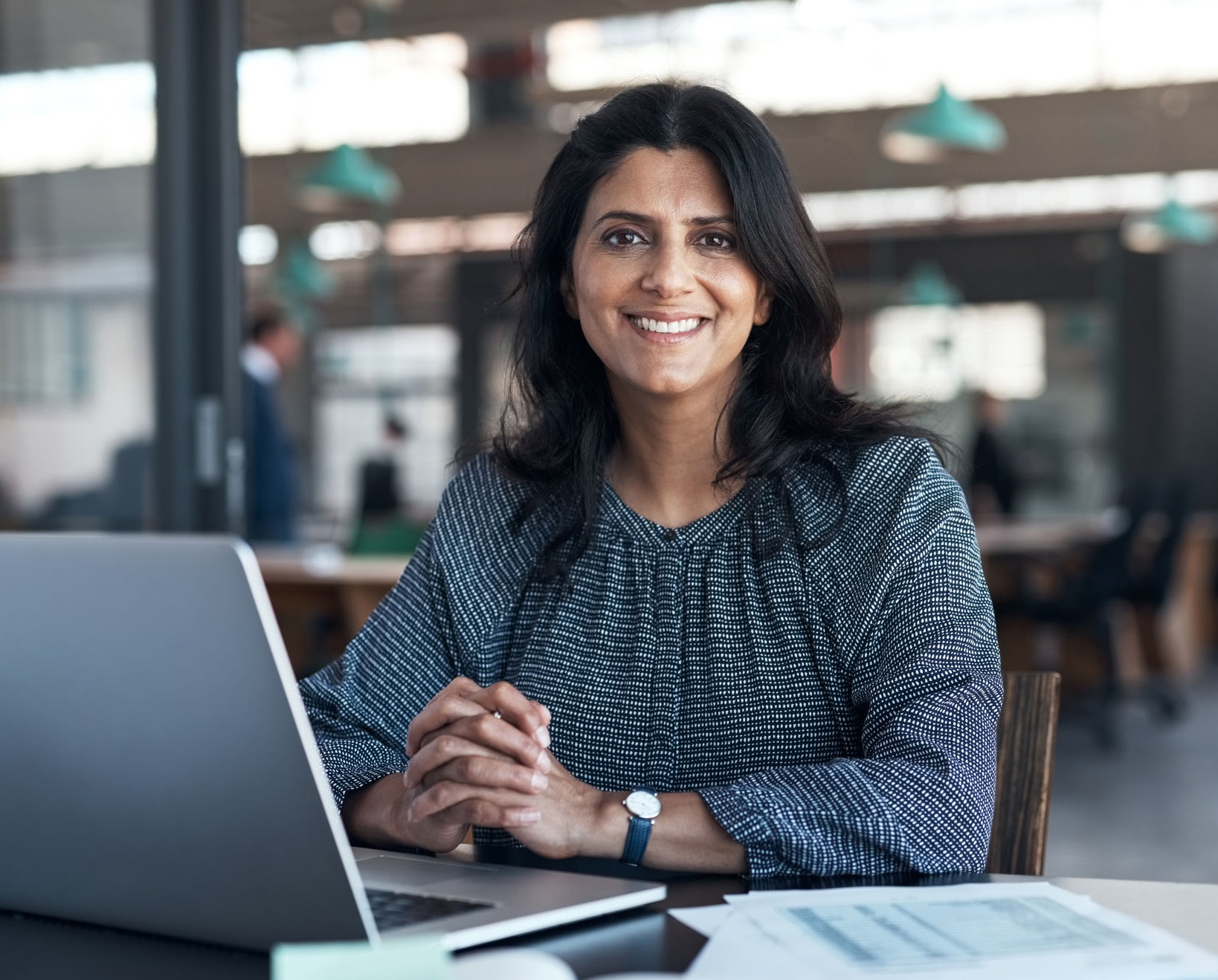 Woman working on her laptop and smiling at the camera
