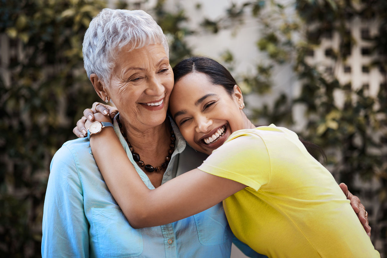 Adult daughter hugging her mum outside